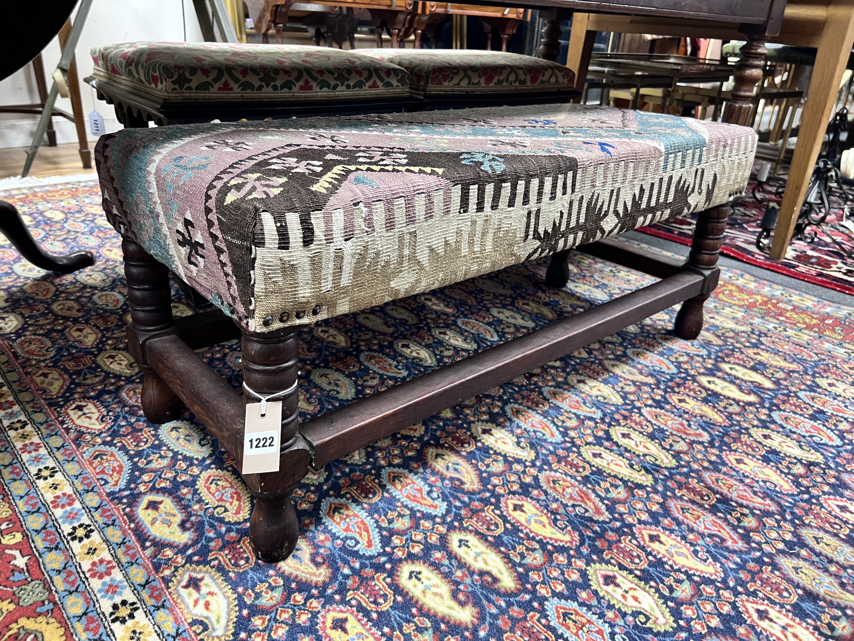 A 17th century style oak stool with contemporary Kilim upholstery, width 100cm